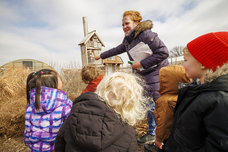 Madeline Williams talks to the children about a bug house in the Backyard Farmer Garden.