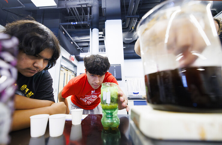 Zach Abourezk, center, and Mike Cayou Jr. watch water slowly drip through a filter to improve its quality during a group’s environmental lab experiment.
