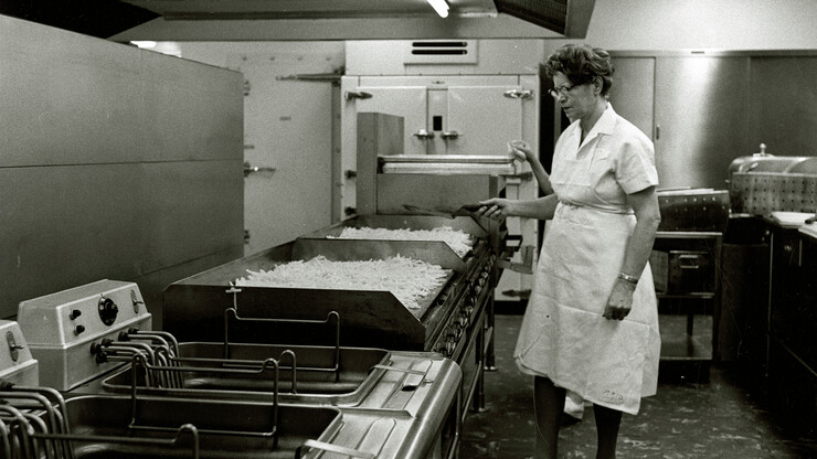 An unidentified woman works the grill in the Selleck Quadrangle dining center in February 1963.