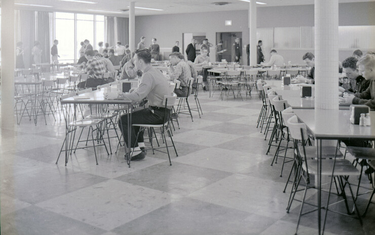 Students sit at traditional dining hall tables and chairs in this February 1963 photo in the Selleck Quadrangle dining center.