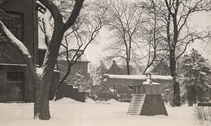 Photo of snowy campus buildings and the Spanish-American War cannon that was on display between 1900 and the start of World War II.