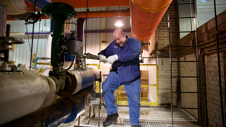 Brian Glaze, a utility operator, opens a valve as a boiler is brought online at the City Campus utility plant.
