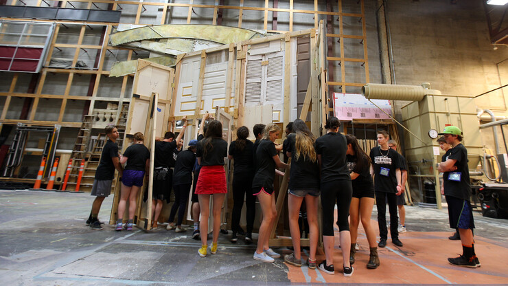 Students from the Denver School of Arts move a portion of the set for "Spring Awakening" into place on June 23. Student troupes work with Lied Center staff to stage productions during the International Thespian Festival.