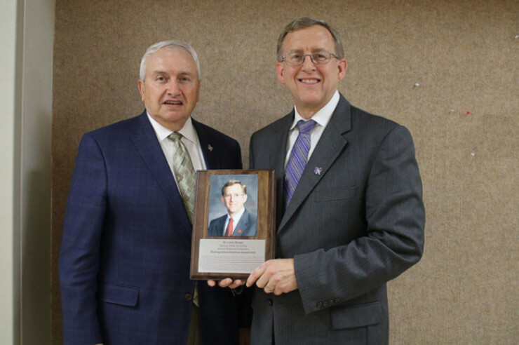 Larry Berger (right) accepts the distinguished alumnus award from Ken Odde, head of Kansas State University's Department of Animal Sciences and Industry.
