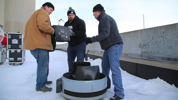 John Finical (from left), Alex Bechdolt and Patrick Bressman, all of Omaha-based TMS Production Integration, install a projector that will illuminate the north side of Memorial Stadium with the N150 logo during the Glow Big Red event, Feb. 14-15. The fixture is the first of 244 lights being installed to illuminate 19 campus buildings in preparation for the close of Charter Week. All but eight of the lights use energy-saving LED technology. The crew will also install red colored gels over existing exterior lights on four additional buildings, including Love Library. Other buildings, including Sheldon Museum of Art, have permanent exterior lights that are switched to red for the event.