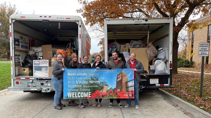 College of Education and Human Sciences volunteers stand before a truck of donations. 