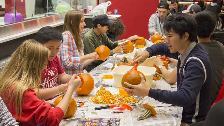 Coffee Talks participants carved pumpkins as part of a Halloween discussion in October 2017. Along with cultural conversations, the series offers occasional hands-on activities.
