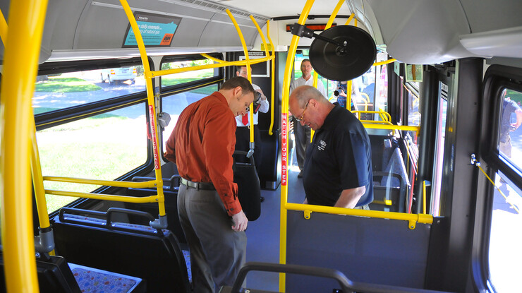 UNL's Dan Carpenter and Bill Manning walk through StarTran's new compressed natural gas-powered bus after the June 13 announcement on East Campus.