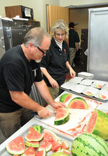 Housing employees (from left) Jode Poley and Karen Standley prepare watermelon for the All-University Picnic, which followed the Sept. 17 State of the University Address. The picnic moved inside the Van Brunt Visitors Center due to inclement weather.