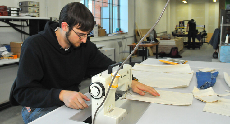 Taner Fairchild works on an apron as part of a lab project in the "Making for Innovation" course.