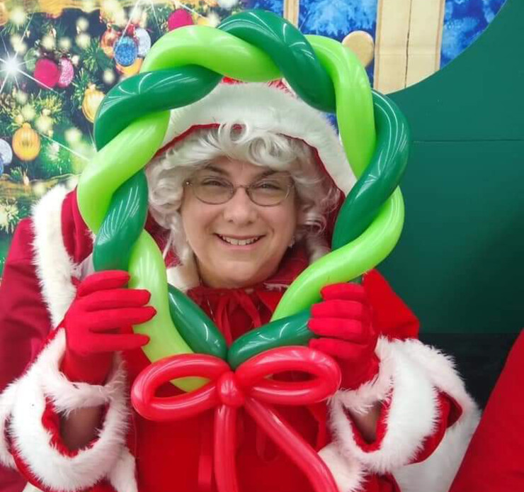 Jeanne Bonnett displays one of her balloon constructions while playing as Mrs. Claus.