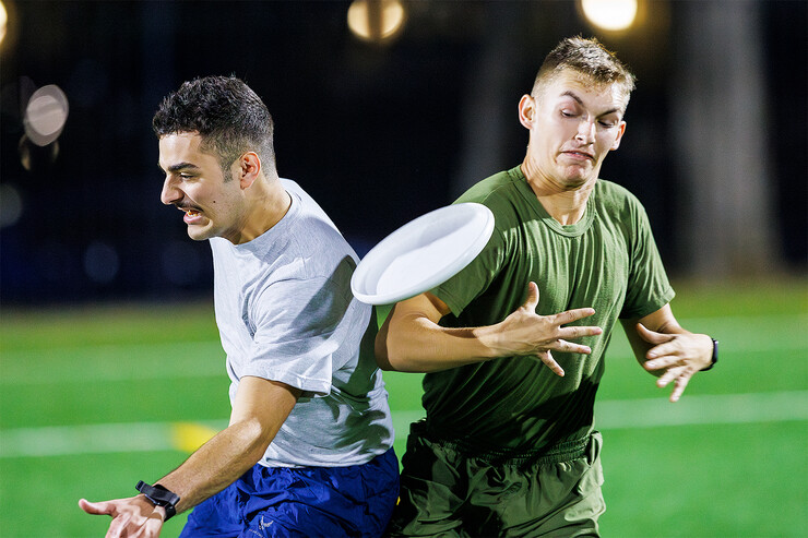 An Air Force ROTC cadet collides with a Navy ROTC midshipman during a game of ultimate frisbee