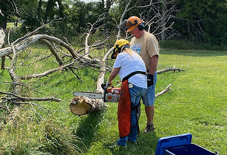 Volunteers learn chainsaw safety.