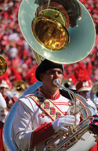 A member of the Cornhusker Marching Band plays the sousaphone during a halftime show. The band is hosting "Tuba Day" as part of a student recruitment push.