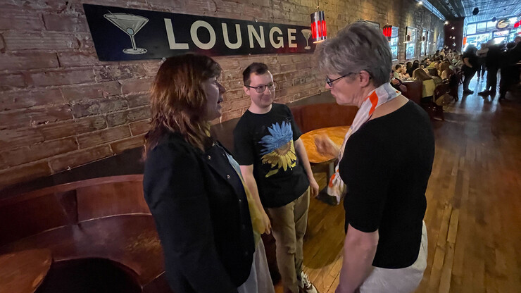 Patrice McMahon (from left) and Lukasz Niparko talk with Regina Werum, professor of sociology, during the UNL for Ukraine event. All proceeds from the fundraiser will be used to support refugees from Ukraine.