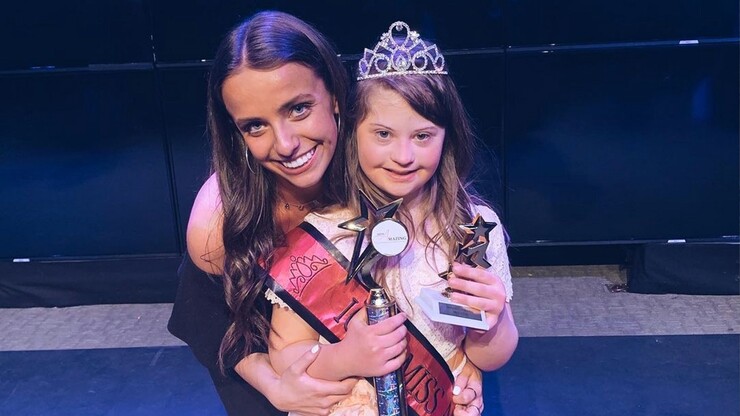 Laura poses with a young girl in a crown at the Iowa Miss Amazing competition.