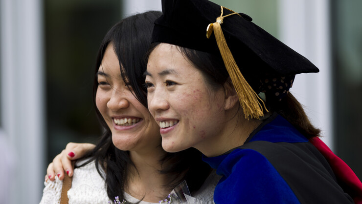 Lingling Yuan (left) poses with Yonghua Teng after the All-University Commencement at Pinnacle Bank Arena on Aug. 16.