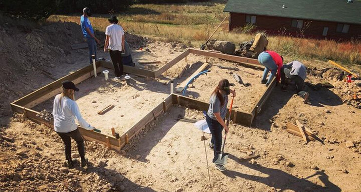 Students set the basic foundation for the micro-dwelling at Cedar Point Biological Station. Work on the project will continue this summer with completion in the fall.