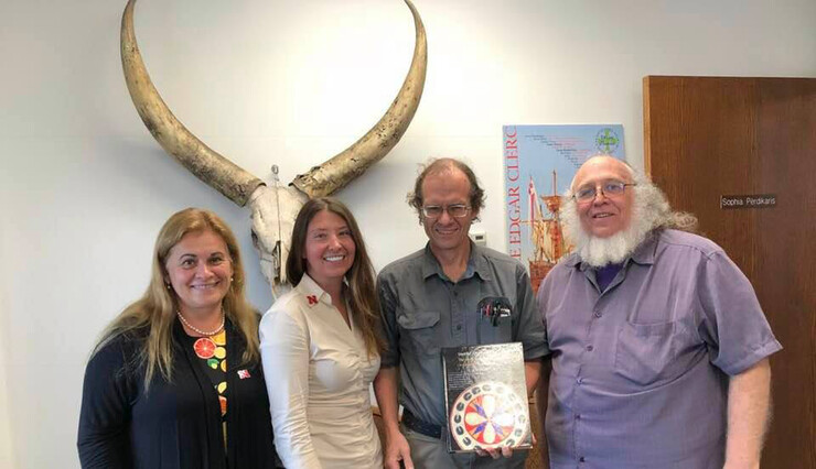 Members of the university community pose with the new Omaha language book. Pictured (from left) is Sophia Perdikaris, a student who learned the Omaha language from Mark Awakiuni-Swetland; Kat Bickert, chair and professor of anthropology; and Rory Larson and Loren Freichs, part of the team that completed the book.
