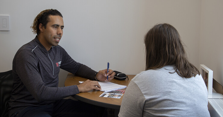 A peer coach in Big Red Resilience and Well-being talks to a student in the University Health Center.