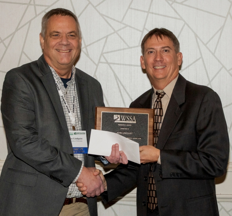 John Lindquist (left) receives the Weed Science Society of America's Outstanding Research Award from Stanley Culpepper, professor and extension weed scientist at the University of Georgia.