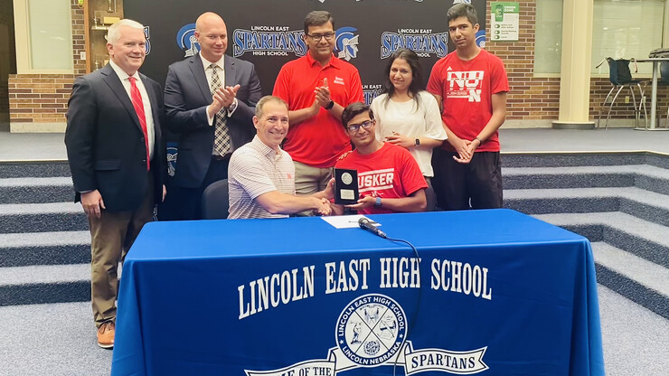 Shrey Agarwal (seated, at right), senior at Lincoln East High School, signed May 17 as the University of Nebraska’s Presidential Scholarship recipient. Others celebrating with Shrey were (from left) Tim Clare, regent; Casey Fries, principal of Lincoln East; Chris Kabourek, NU interim president; Lalit and Sarika Agarwal, Shrey’s parents; and Arnav Agarwal, Shrey’s younger brother.