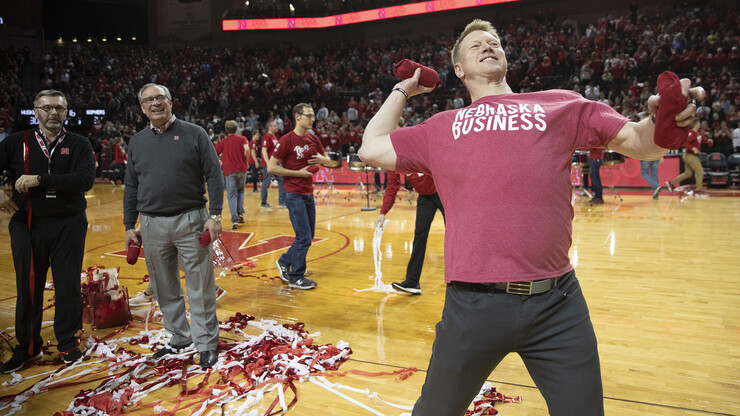 Head football coach Scott Frost, Nebraska's head football coach, shows off his throwing form as he hurls T-shirts into the crowd during the halftime celebration. He was joined on the court by Chancellor Ronnie Green and Bill Moos, athletic director.