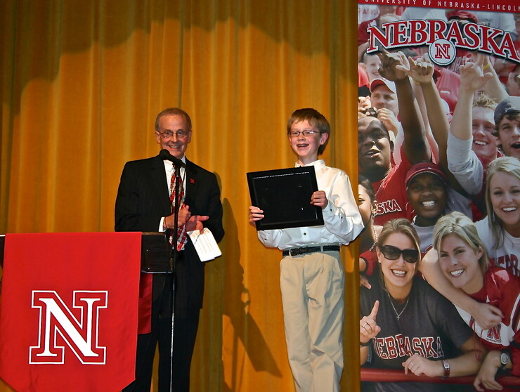 In this 2010 photo, Chancellor Harvey Perlman offers junior high student Henry Harrison a scholarship.