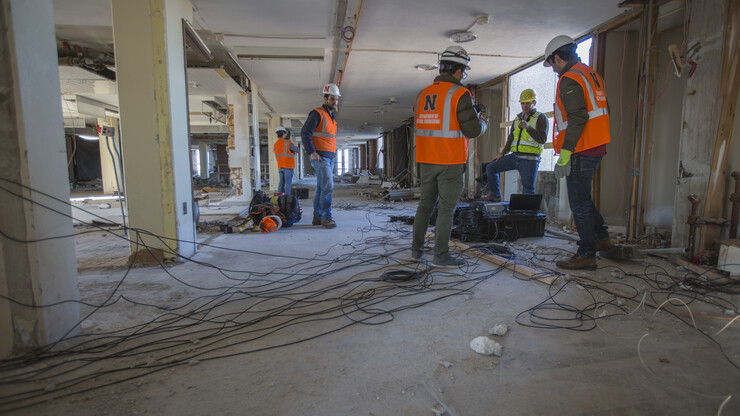 Nebraska's Richard Wood (in yellow) and members of his research team prepare to collect sensors and cables after completing a sensing survey of Pound Hall on Dec. 2. The research project is creating a complete picture of how dynamics of Cather and Pound halls are changing as demolition crews prepare the towers for a Dec. 22 implosion.