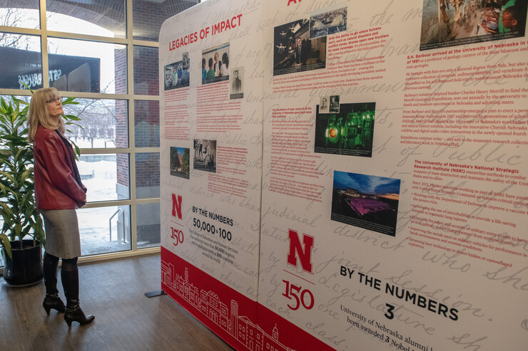 Nebraska's Diane Mendenhall reads about a key historic moment in the university's history as she looks at the N150 traveling exhibition in the Nebraska Union.
