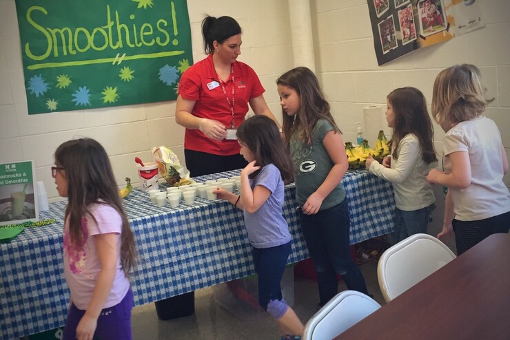 Nebraska Extension Educator Kayla Colgrove shares smoothie samples with Tri County Public Schools students during a recent farmers market at the school.