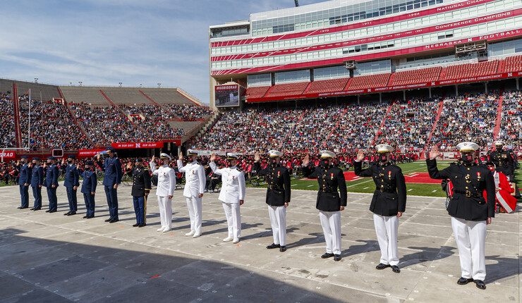 Air Force, Army and Naval ROTC members recite the oath of enlistment during the morning undergraduate commencement ceremony May 8 at Memorial Stadium. Some then changed into regalia to graduate with their colleges.