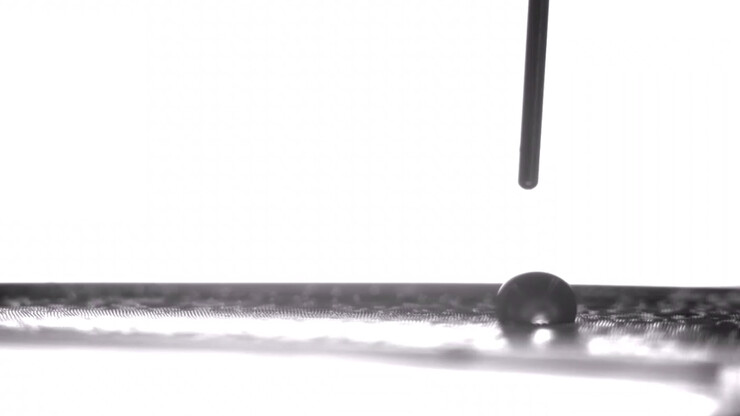 A microscopic droplet of water being deposited onto an elastic silicone film. By stretching and relaxing their specially designed films, University of Nebraska–Lincoln chemists Stephen Morin and Ali Mazaltarim have demonstrated unprecedented control over the movement of liquid droplets on flat surfaces. That control could make the technique useful in self-cleaning materials, water harvesting and other applications.