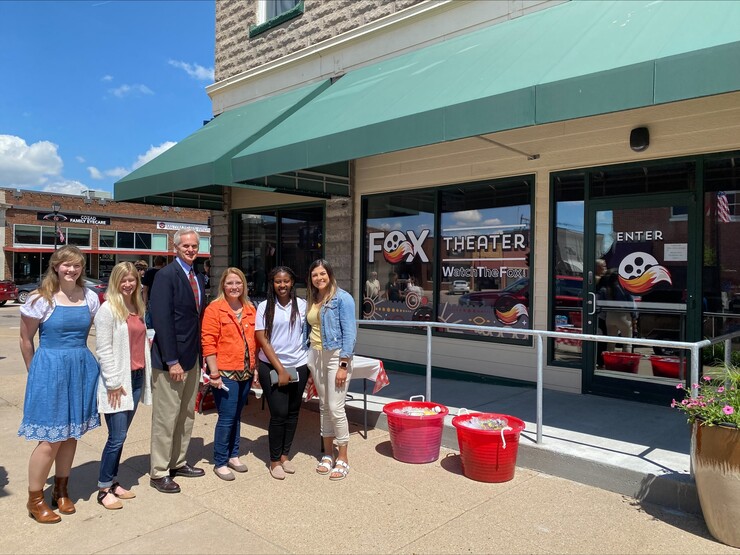 Student fellows Alicia Pannell (left), Tori Pedersen (second from left) and Janet Kabetesi (fifth from left) and community fellows Andrea McClintic (fourth from left) and Stephanie Novoa (sixth from left) are pictured with Lt. Gov. Mike Foley (third from left) at the Fox Theater ribbon cutting in Cozad, Nebraska.
