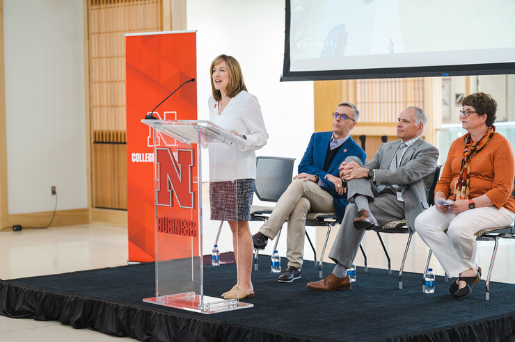 Kathy Farrell, dean of the College of Business, speaks during the announcement of the new Nebraska Business focus program at Lincoln’s Standing Bear High School on May 10. Seated behind her are (from left) Chancellor Ronnie Green, Lincoln Public Schools Superintendent Steve Joel and Standing Bear Principal Sue Cassata.