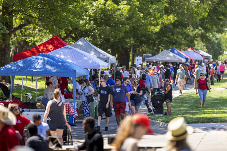 A crowd of people walks by vendor tents during an East Campus Discovery Days farmers market in Lincoln in summer 2021.