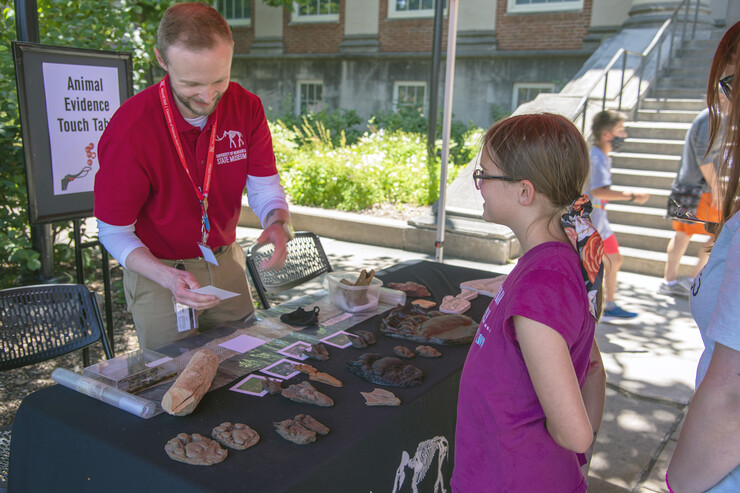 A young visitor chats with Adam Eakin, assistant director of the NU State Museum, at an animal traces identification activity station during the 2021 Archie’s Party.