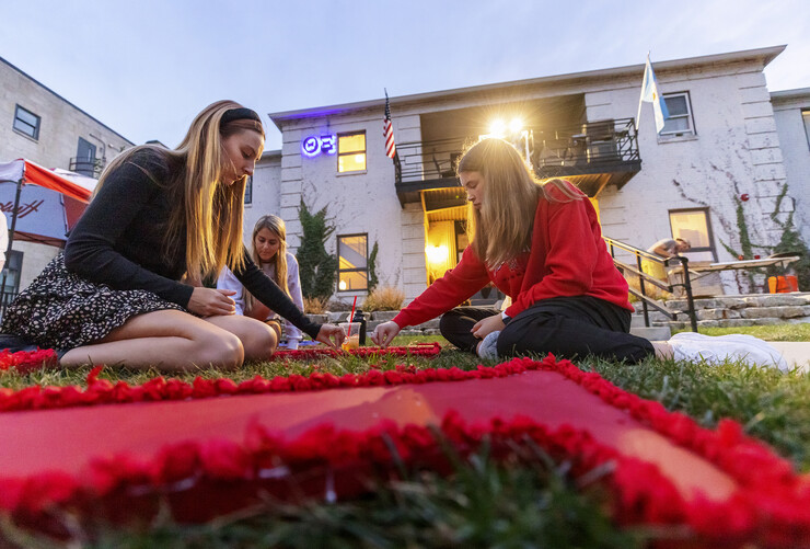 Three members of Chi Omega sorority work on a lawn display outside the Theta Xi fraternity for the 2021 homecoming week. Lawn displays for 2022 will be completed and judged Sept. 30.