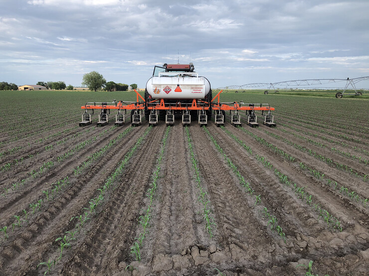 Flame weeder equipment is used on a field during a Systems Approach to Weed Control workshop.