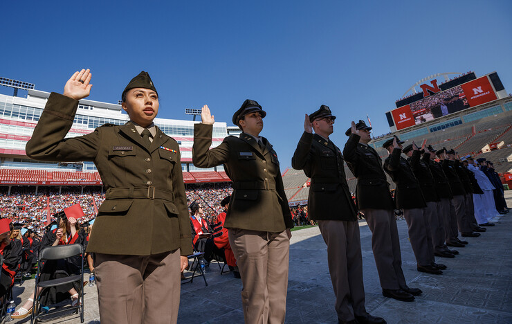 Air Force, Army and Naval ROTC members recite the oath of enlistment during the undergraduate commencement ceremony May 20 at Memorial Stadium.