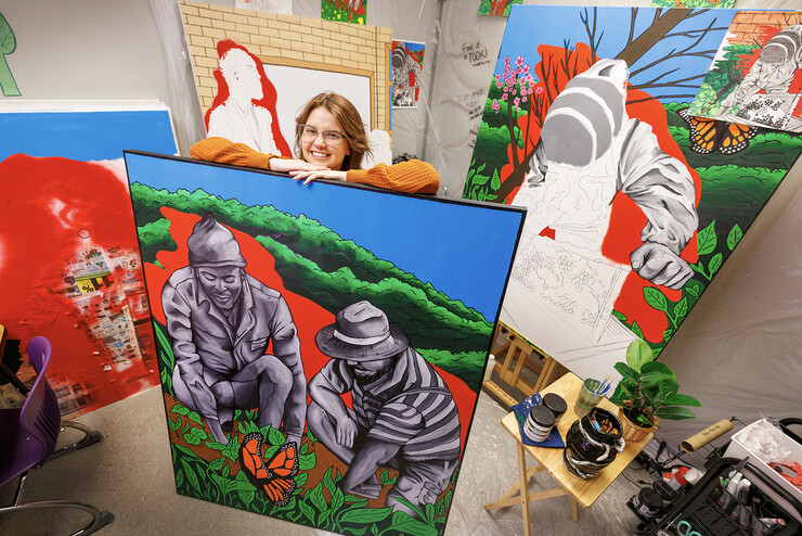 Lincoln Northeast student Peyton Miller stands among colorful murals.