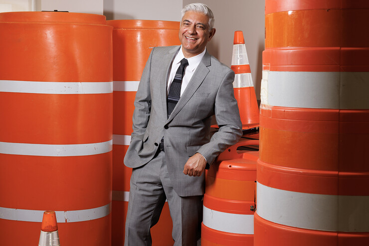 Aemal Khattak, director of the Mid-America Transportation Center, poses amid orange traffic barrels and cones.