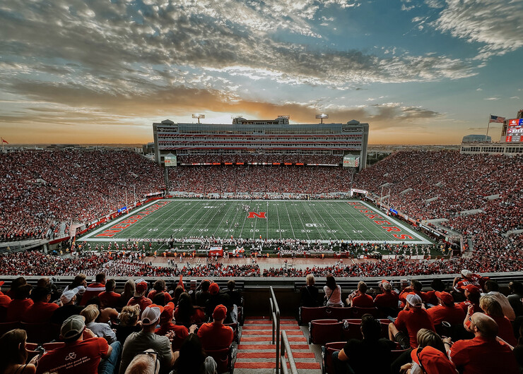 Memorial Stadium, full of fans, with colorful sky overhead