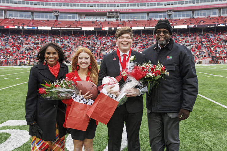 Newly crowned homecoming royalty Hannah-Kate Kinney (second from left) and Preston Kotik (third from left) are joined by Chancellor Rodney Bennett (right) and his wife, Temple (left), on the field at Memorial Stadium.