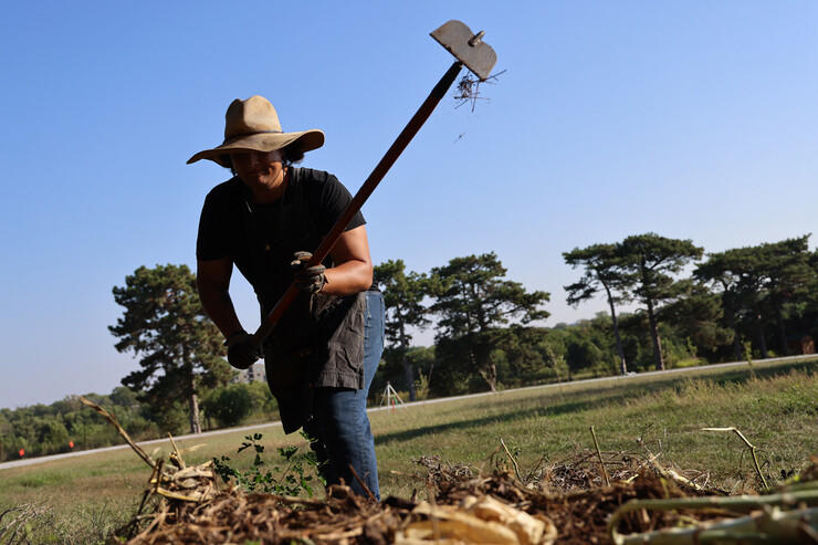 Timothy Thielen breaks up a compost pile with a hoe as part of the Indigenous Youth Food Sovereignty Program.