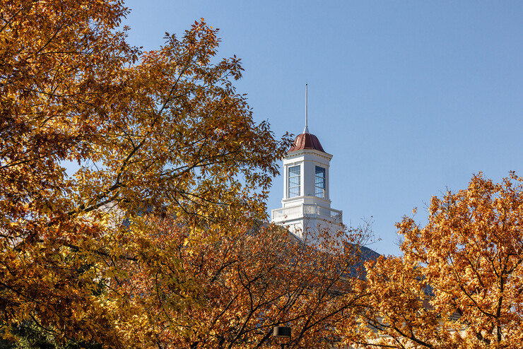 The Love Library cupola behind trees with autumn leaves