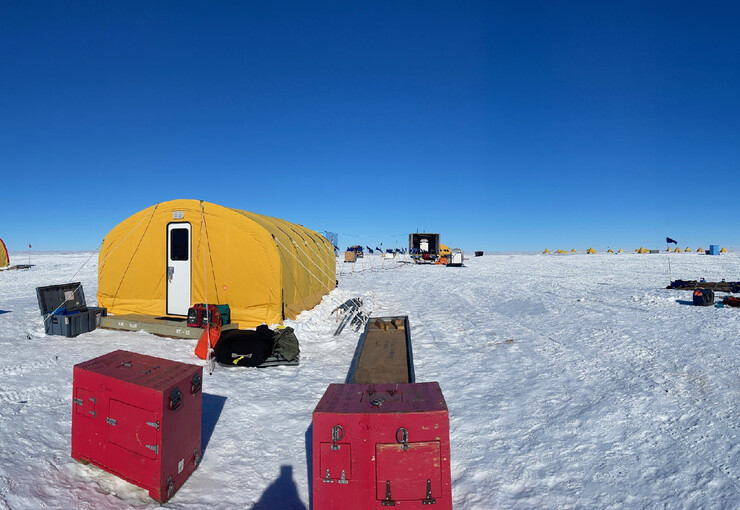 A yellow living unit at an Antarctic ice drill site.