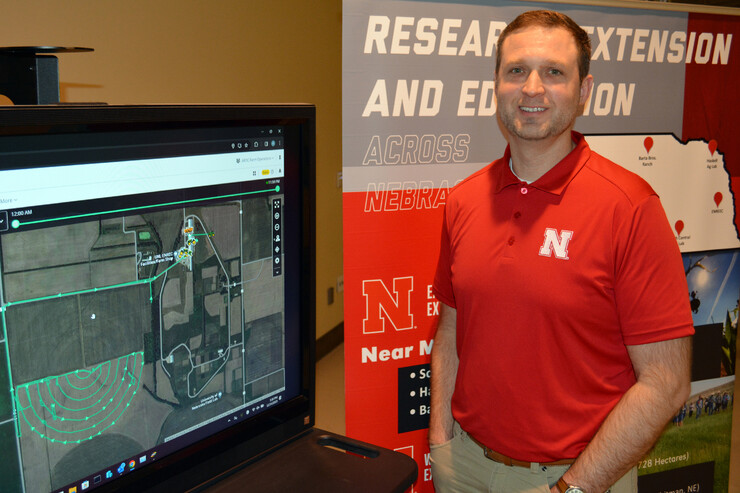 Nate Thorson, research manager for NFarms, stands next to a monitor.