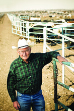 Paul Engler, wearing a cowboy hat, with cattle behind him