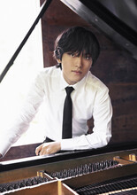Yunchan Lim poses over a grand piano.